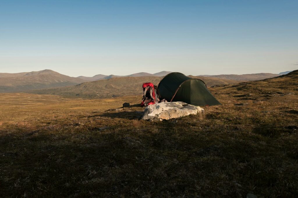 Bivouac ultralight au lever du soleil dans la montagne, randonneur en bivy bag minimaliste