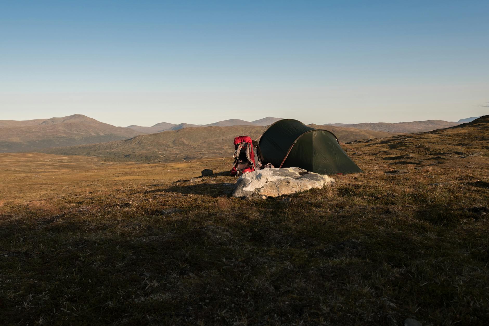 Bivouac ultralight au lever du soleil dans la montagne, randonneur en bivy bag minimaliste