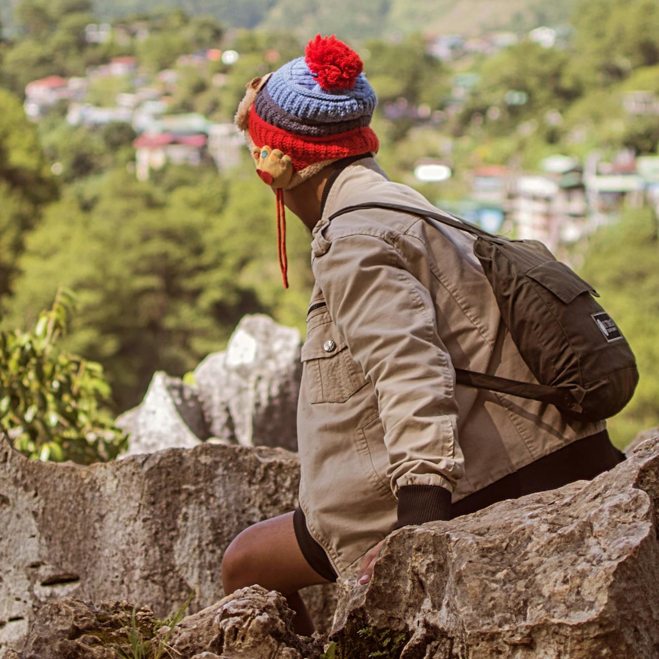 Sac à dos et chaussures de randonnée enfant en détail posés sur un rocher en forêt