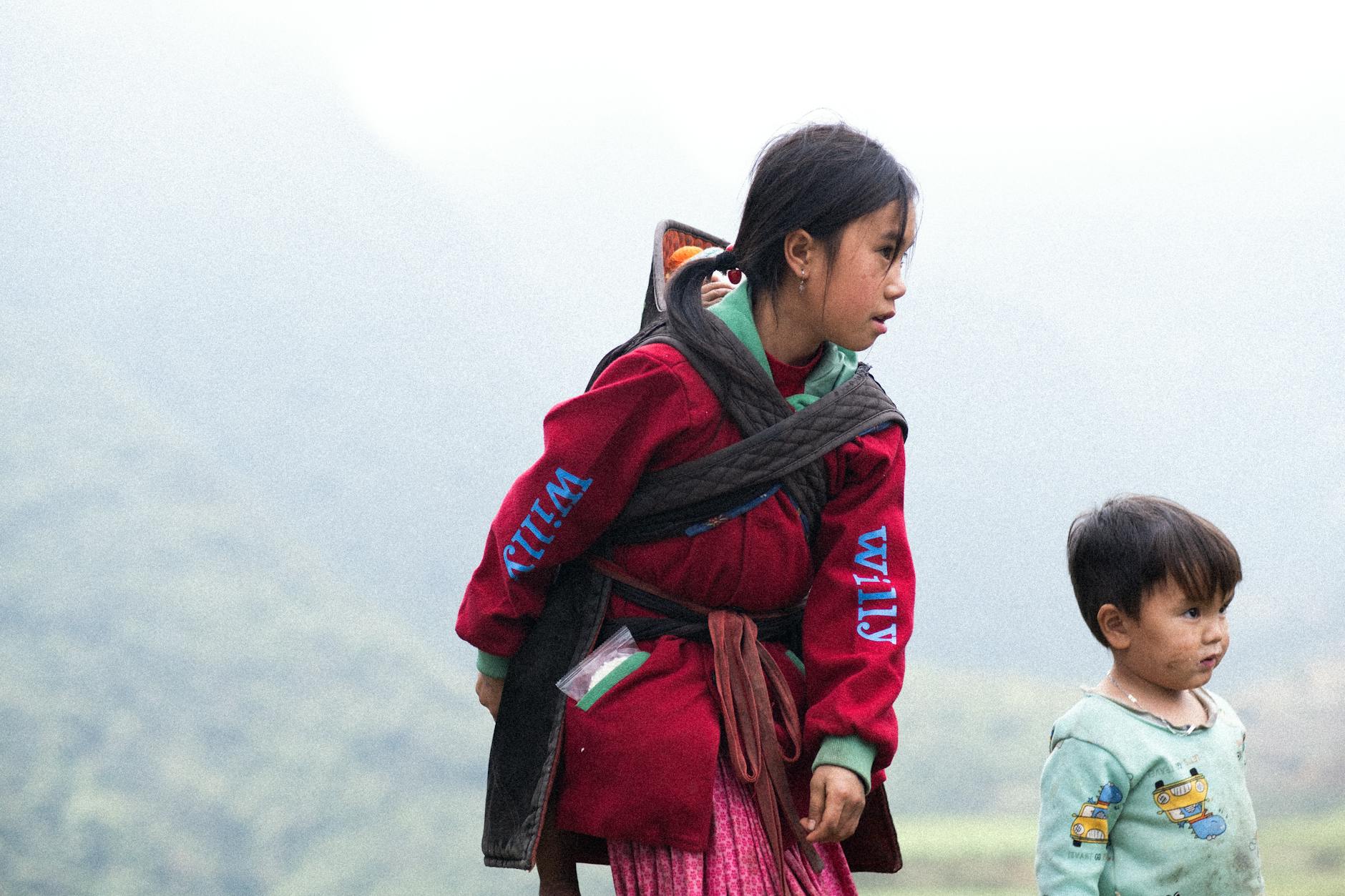 Enfants explorant un paysage de montagne avec des livres et des cartes topographiques au printemps 2026