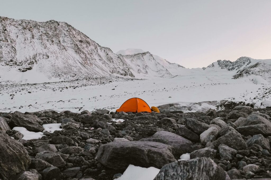 Bivouac de randonnée en montagne avec matelas gonflable installé sous tente au coucher du soleil