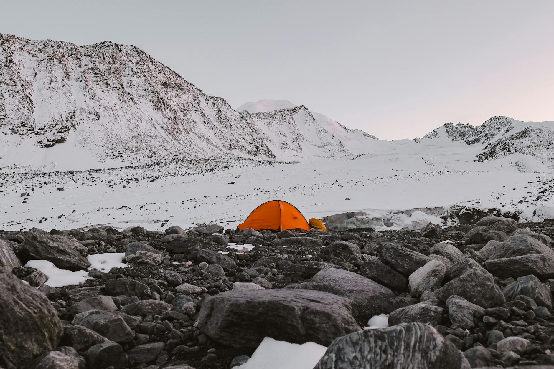 Bivouac de randonnée en montagne avec matelas gonflable installé sous tente au coucher du soleil