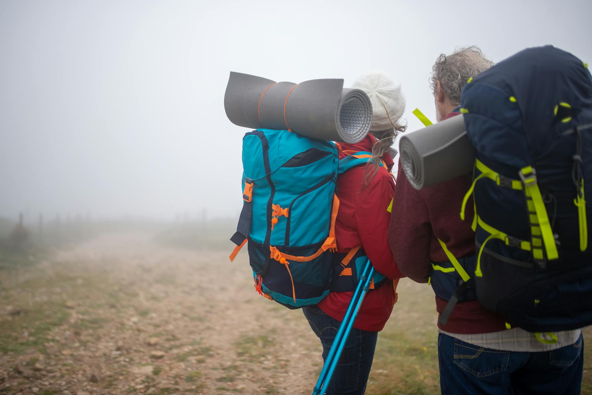 Couple de seniors en randonnée sur un sentier de montagne, marche douce et matériel adapté