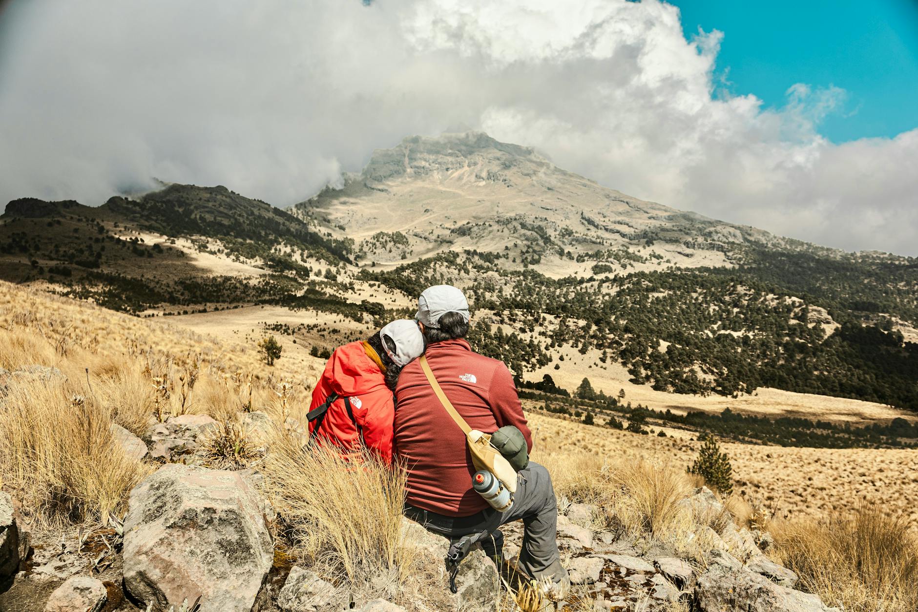 Famille en randonnée sur un sentier de montagne, paysage alpin lumineux, équipement adapté pour week-end outdoor