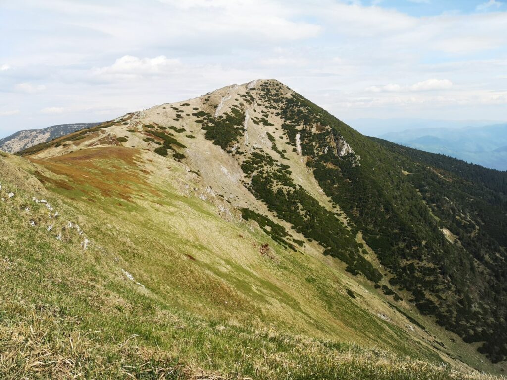 Randonneur sur une crête de montagne ensoleillée en été, forte exposition aux rayons UV en altitude