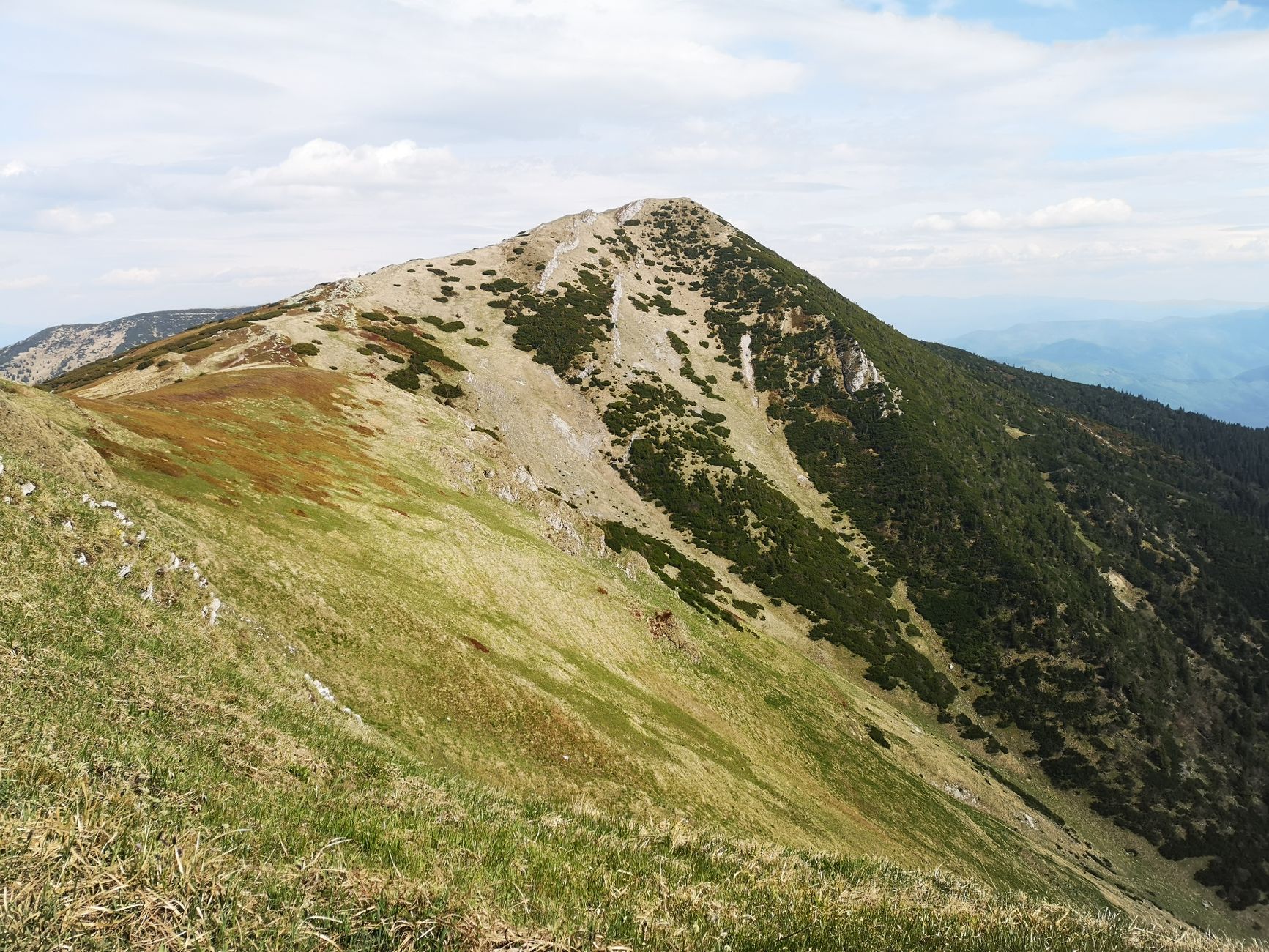Randonneur sur une crête de montagne ensoleillée en été, forte exposition aux rayons UV en altitude