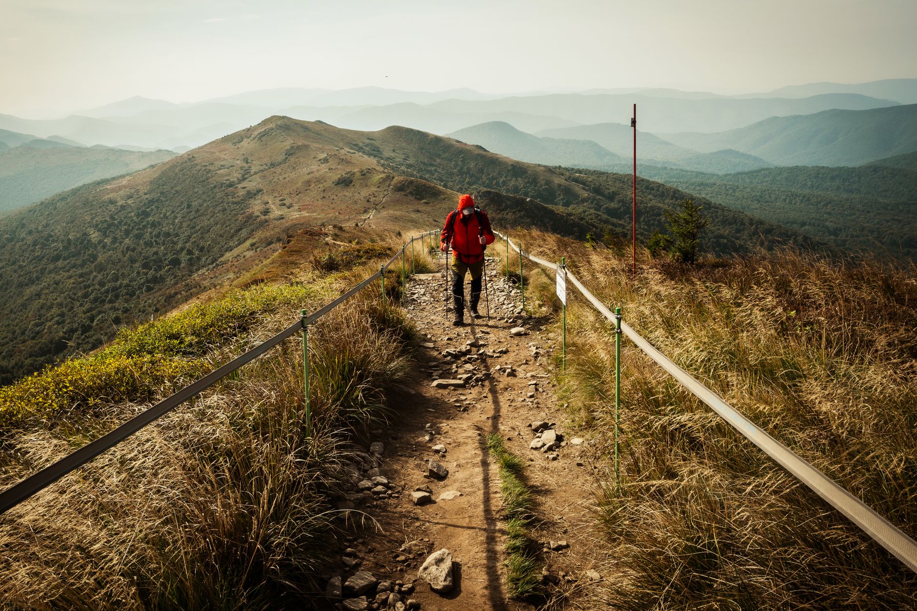 Randonneur buvant de l'eau sur un sentier de montagne ensoleillé pour rester hydraté en 2026