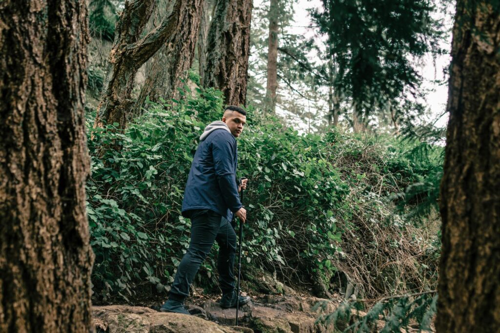 Randonneur descendant un sentier de montagne avec deux bâtons de randonnée, posture droite et appui contrôlé