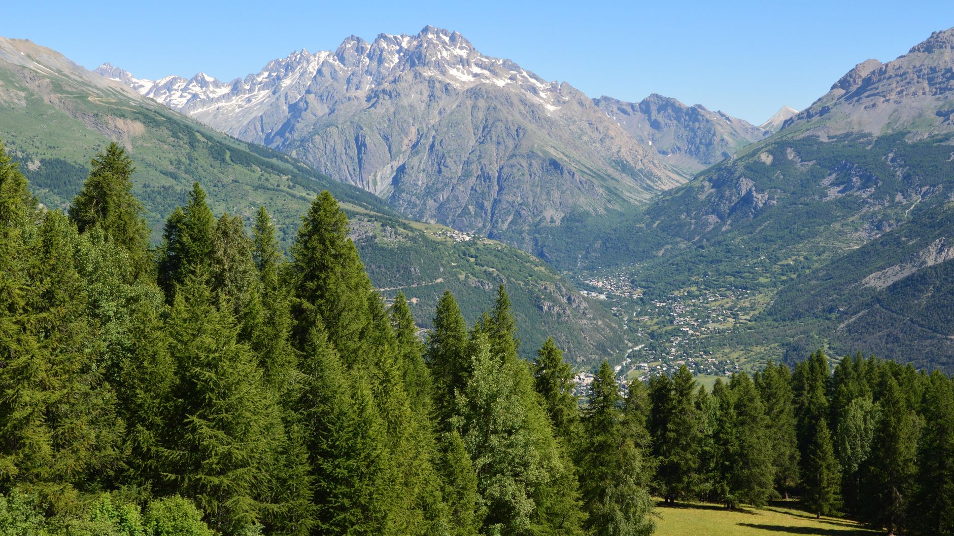 Panorama de montagne alpine sous le soleil estival avec sommets et ciel d'altitude en été 2026