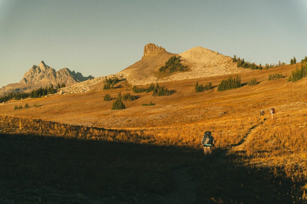 Chaussures légères posées devant une tente de bivouac au coucher du soleil en montagne, illustrant le confort après une randonnée en 2026