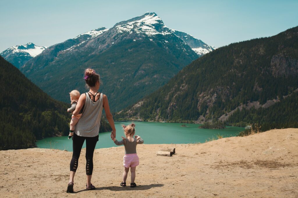 Enfant et parent en randonnée sur un sentier de montagne, initiation en famille à la découverte des sommets en 2026