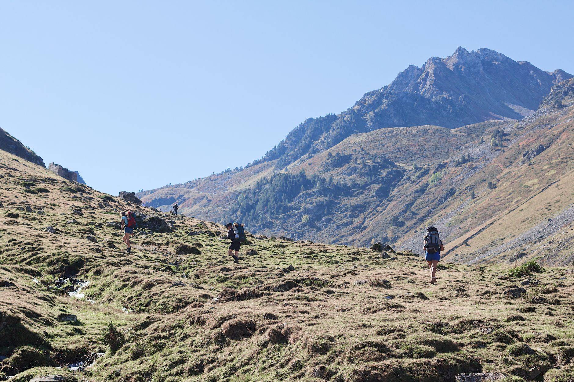 Sentier de randonnée dans les Pyrénées sur le tracé du GR10, paysage de montagne avec crêtes et vallées verdoyantes en été