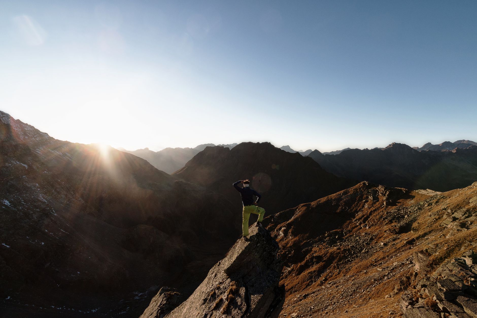 Crête rocheuse alpine baignée de lumière du lever du soleil, illustrant l'ascension engagée de La Meije dans le massif des Écrins