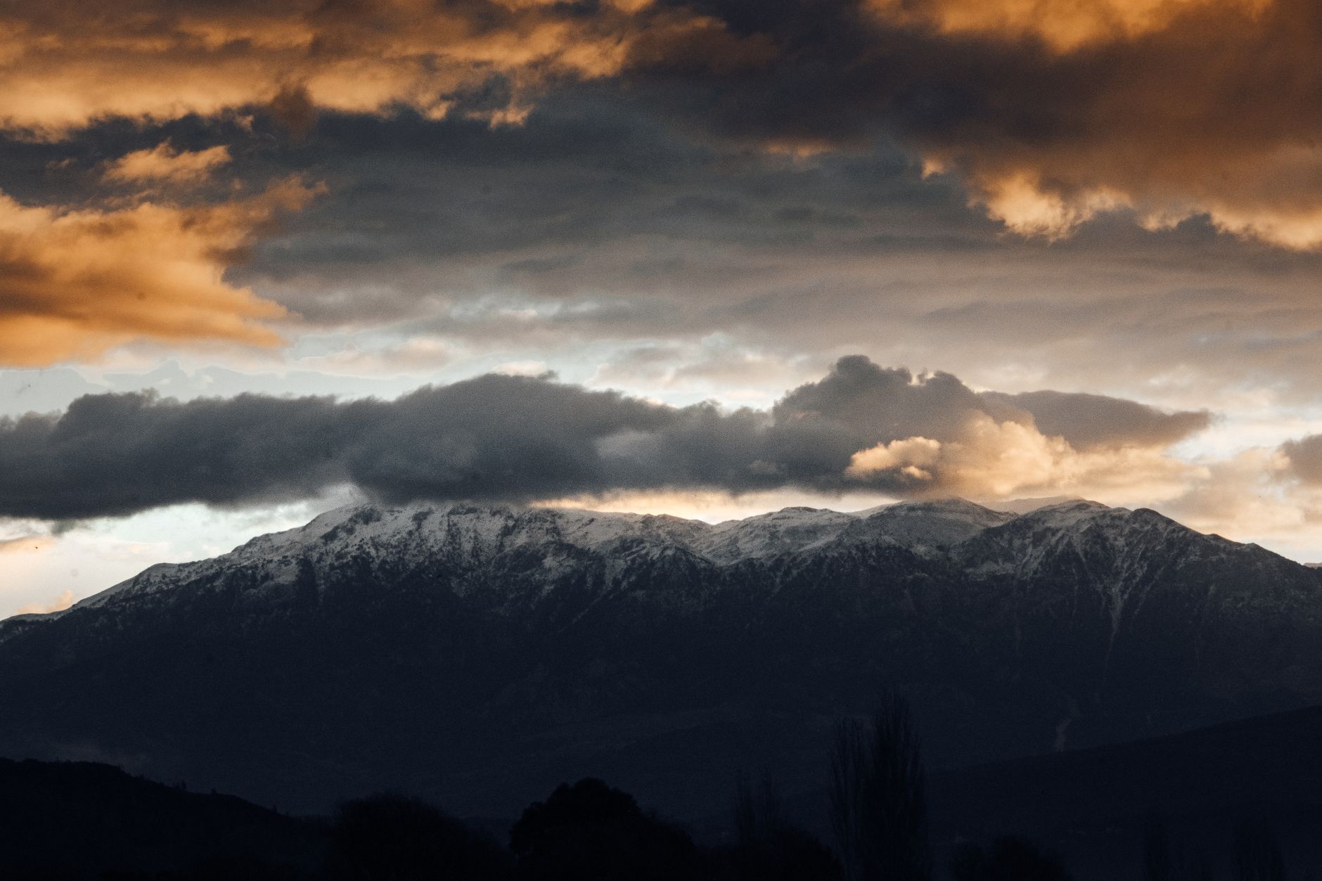 Ciel d'orage menaçant au-dessus d'une chaîne de montagnes, illustrant les risques météo brusques en altitude en randonnée