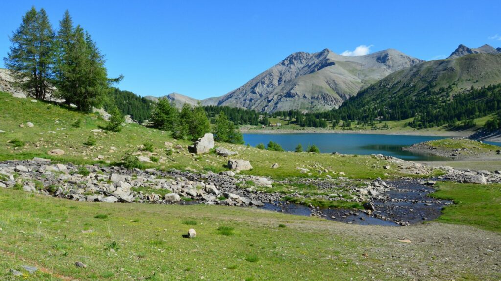 Paysage de montagne du parc national du Mercantour avec lac d'altitude turquoise entouré de sommets rocheux et de sentiers de randonnée