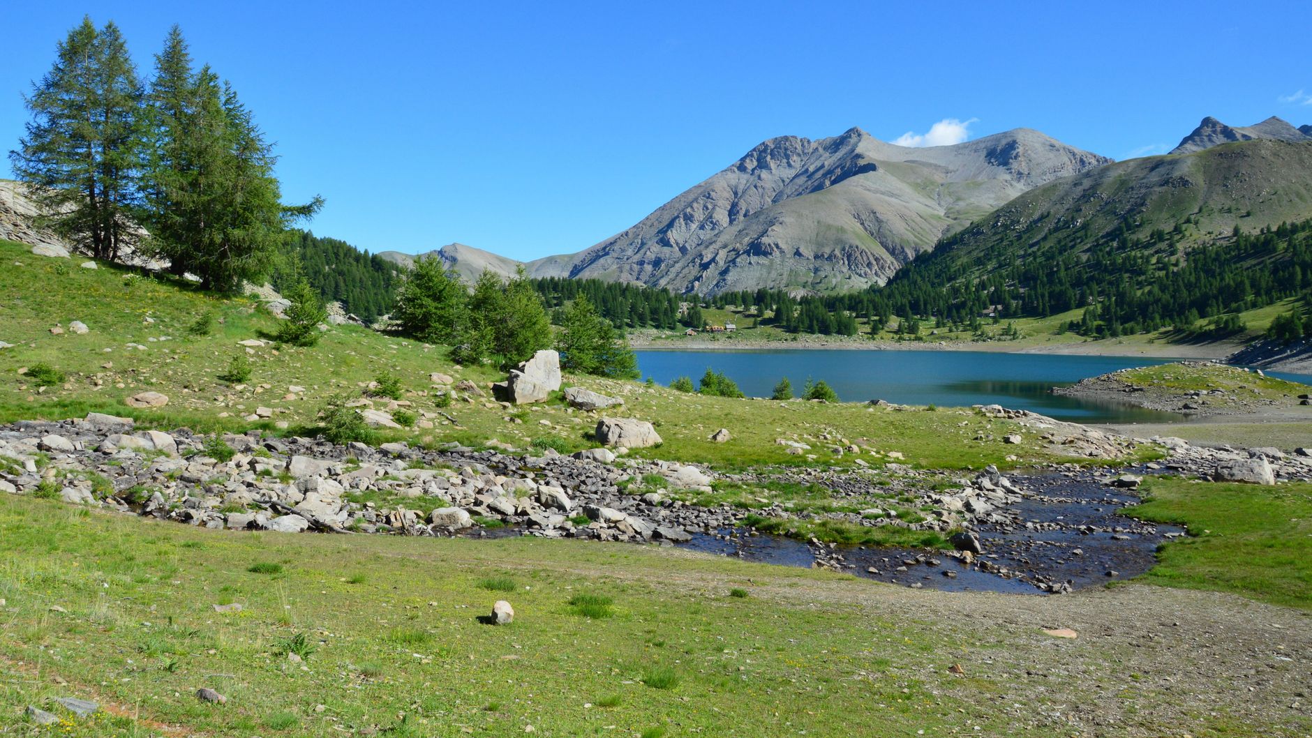 Paysage de montagne du parc national du Mercantour avec lac d'altitude turquoise entouré de sommets rocheux et de sentiers de randonnée