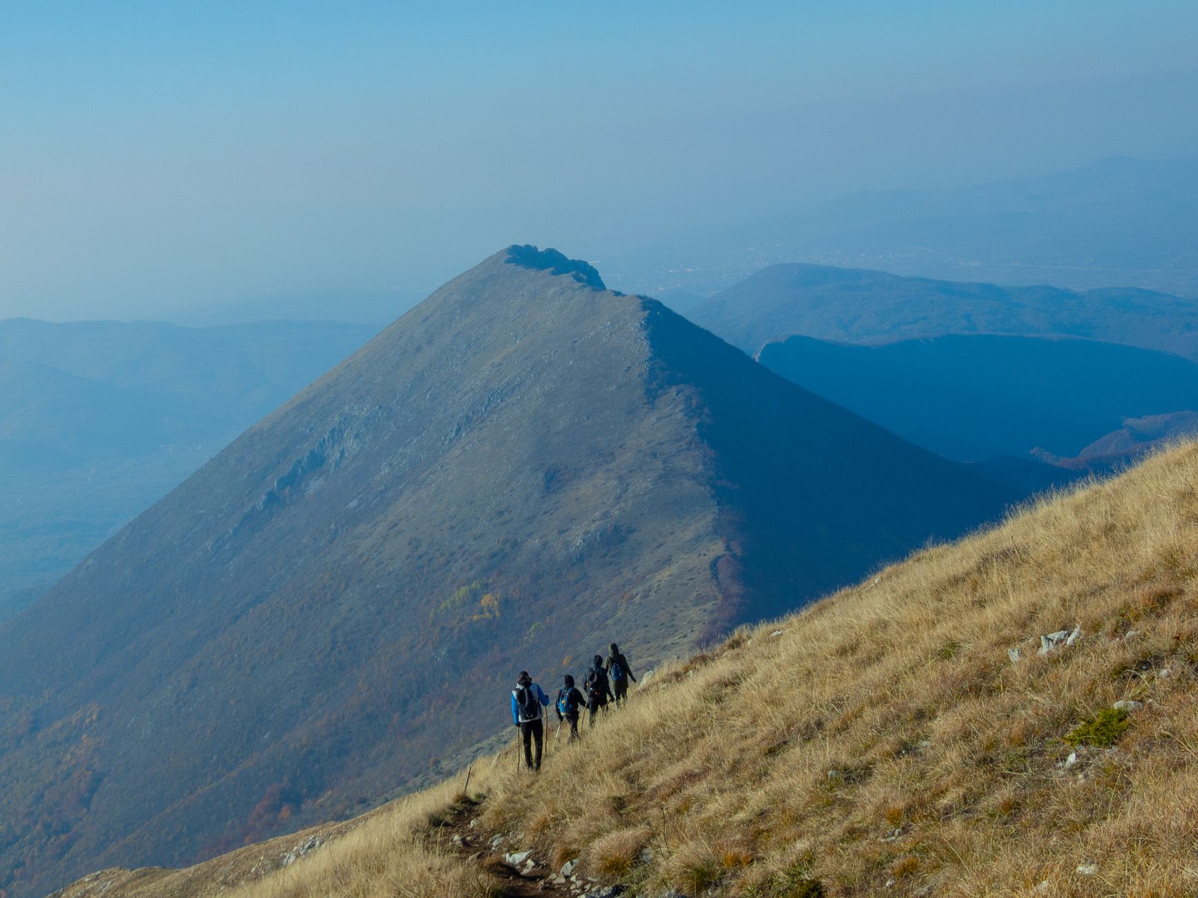 Groupe de randonneurs progressant sur un sentier de montagne panoramique en France, illustration du bilan FFRandonnée 2026 sur la pratique de la randonnée pédestre