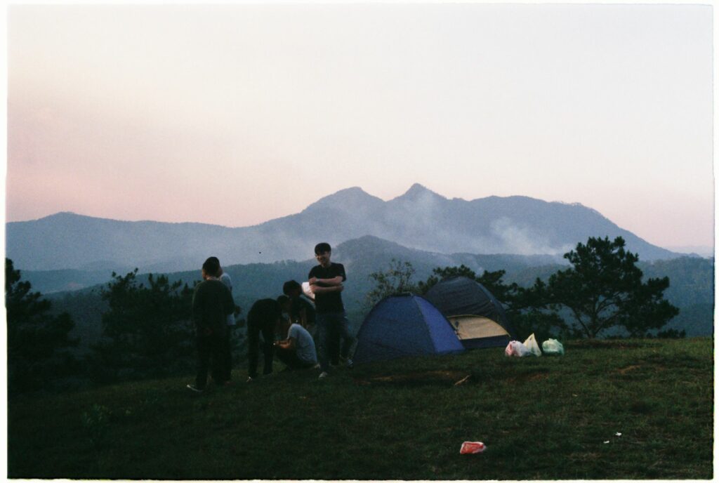Tente de camping familiale installée en montagne au coucher du soleil pour un premier bivouac en famille en 2026