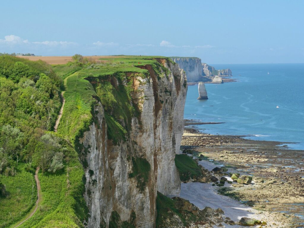 Falaises de craie normandes bordant un sentier de randonnée côtier avec vue panoramique sur la Manche